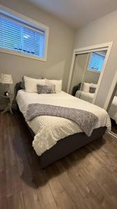 a bedroom with a bed and a large window at Home Suite Home in Promontory Heights 1bdrm suite in Chilliwack