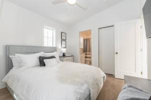 a white bedroom with a white bed and a ceiling fan at Guest House Getaway - 1 Bdrm 1 Bath Carriage Home in Chilliwack