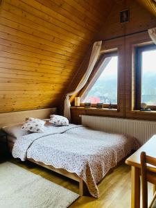 a bedroom with a bed and a large window at Apartament Centrum Zakopane in Zakopane