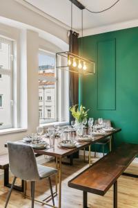 een eetkamer met een lange tafel en groene muren bij Apartment Botanika in Wenen