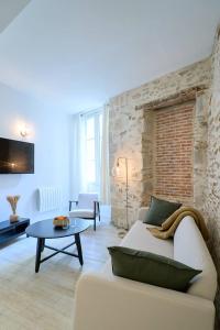 Una sala de estar con un sofá blanco y una mesa. en La loge des Carmélites Coeur de Nantes WIFI, en Nantes