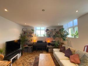 a living room with a couch and a piano at Biophilic Duplex - Family & Pet Friendly in Sheffield