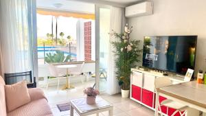 a living room with a couch and a tv and a table at Adeje Beach Holiday Home Viña del Mar in Playa Fañabe