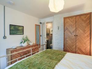 a bedroom with a large bed and a wooden door at The Old Stables in Totnes