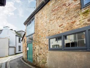 an old brick building with a green door on a street at The Old Stables in Totnes