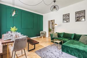 een woonkamer met groene muren en een groene bank bij Apartment Botanika in Wenen