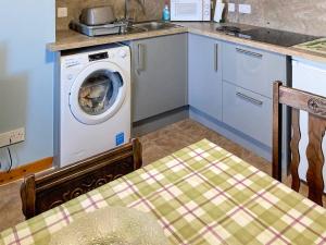 a kitchen with a washing machine and a sink at 3 Breckery in Staffin