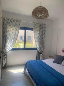 a bedroom with a blue bed and a window at Marassi in El Alamein