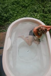 a woman is in a bath tub with water at Sugi wooden pod in York