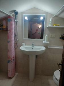 W łazience znajduje się umywalka, lustro i toaleta. w obiekcie Locazione turistica vicino Orvieto w mieście Orvieto Scalo
