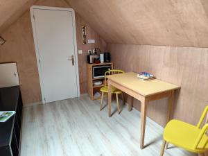 eine kleine Küche mit einem Tisch und Stühlen in einem Zimmer in der Unterkunft Le goéland in Créances