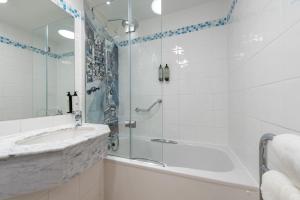 a bathroom with a shower and a sink and a tub at Holiday Inn - Glasgow Airport by IHG in Paisley