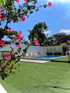 a building with a swimming pool and pink flowers at HUANCHACO GARDENS in Huanchaco