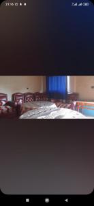 TV con una cama en una habitación con sillas en Auberge amouger assoul en Aït el Hami