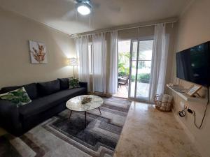 a living room with a couch and a table at 1BDR Private Beach Access at Los Corales PuntaCana in Punta Cana