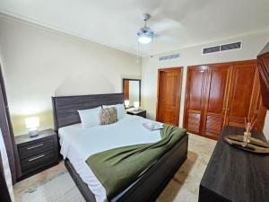 a bedroom with a large bed and a table at 1BDR Private Beach Access at Los Corales PuntaCana in Punta Cana