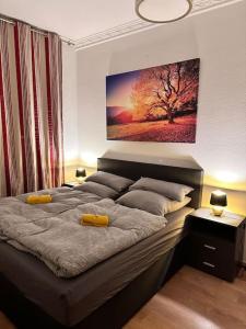 une chambre avec un grand lit avec un tableau au mur dans l'établissement City Altstadt Appartement in unmittelbarer Nähe zu Saale und Marktplatz mit privatem Parkplatz, à Halle-sur-Saale