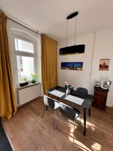 - un salon avec une table à manger et des chaises dans l'établissement City Altstadt Appartement in unmittelbarer Nähe zu Saale und Marktplatz mit privatem Parkplatz, à Halle-sur-Saale