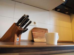 un comptoir avec un bloc à couteaux et une tasse de café dans l'établissement City Altstadt Appartement in unmittelbarer Nähe zu Saale und Marktplatz mit privatem Parkplatz, à Halle-sur-Saale