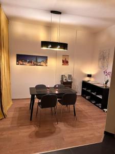 une salle à manger avec une table et des chaises noires dans l'établissement City Altstadt Appartement in unmittelbarer Nähe zu Saale und Marktplatz mit privatem Parkplatz, à Halle-sur-Saale 15 autres photos
