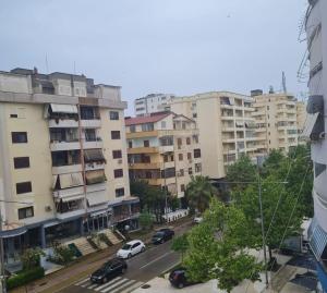 een stadsstraat met auto's geparkeerd voor gebouwen bij Apartment Durres in Durrës