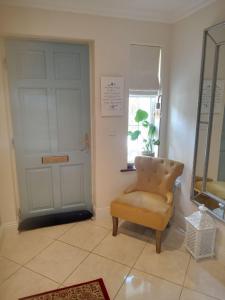 una stanza con una sedia, una porta e uno specchio di El Roi Guesthouse a Waterford