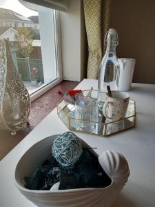El Roi Guesthouse في واتيرفورد: طاولة مع وعاء أبيض وحاوية زجاجية