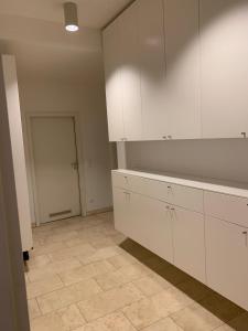 德累斯顿Ferienwohnung für kleine und große Reisegruppe的厨房配有白色橱柜和瓷砖地板