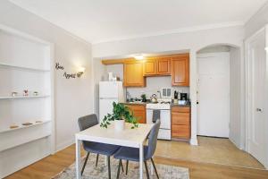 a kitchen with a white table and a white refrigerator at Inviting Studio Apartment in Evanston - Elmgate Manor 403 in Evanston