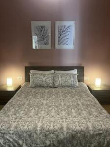 沙拉的住宿－Spacious, Bright, Valley & Sea View Maisonette，一间卧室配有一张大床,配有两个床头柜和两张图片