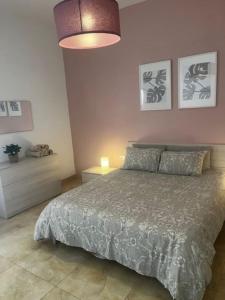 沙拉的住宿－Spacious, Bright, Valley & Sea View Maisonette，一间卧室配有一张床和一盏灯,墙上挂着照片