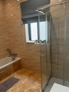 a bathroom with a shower and a sink and a tub at Spacious, Bright, Valley & Sea View Maisonette in Xagħra