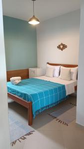 a bedroom with a bed with a blue blanket on it at Pousada Divina Vila in Ilha de Boipeba