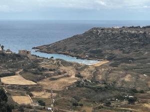 an aerial view of an island with the ocean at Spacious, Bright, Valley & Sea View Maisonette in Xagħra