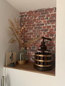a brick wall next to a shelf with a blender at Le Pressoir Macy - Terracobois in Choussy