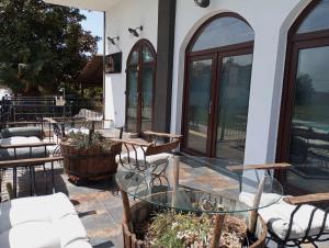 un patio al aire libre con mesas, sillas y ventanas en Villa Camellia, en Vrasná