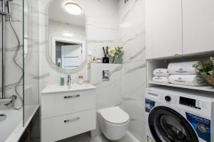 bagno con lavandino e servizi igienici e lavatrice. di TS Gold New Town Apartment & free private parking a Stettino