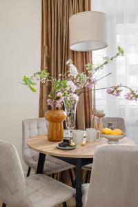 tavolo da pranzo con vaso di fiori di TS Gold New Town Apartment & free private parking a Stettino