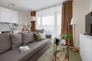 un soggiorno con divano grigio e tavolo di TS Gold New Town Apartment & free private parking a Stettino