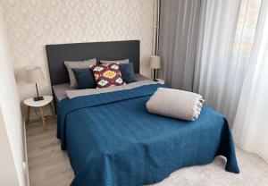 a bedroom with a bed with a blue blanket at Hamina City Apartments in Hamina