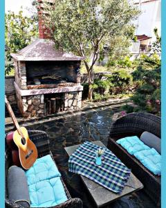 un patio con sofás y una chimenea con guitarra en Villa Camellia, en Vrasná