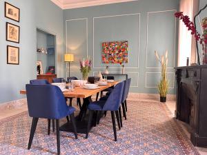 a dining room with a wooden table and blue chairs at Private rooms in authentic apartment in Old town of Tunis, near Medina in Tunis