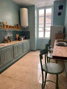 - une cuisine avec des murs bleus, une table et des chaises dans l'établissement Rooms in luxurious apartment in Old town of Tunis, near Medina, à Tunis