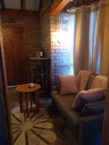 uma sala de estar com um sofá e uma mesa em Chalés Corucacas em Cambará