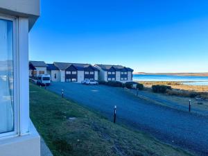 a row of houses with cars parked in front of the ocean at Edenia Hotel & Nature in El Calafate