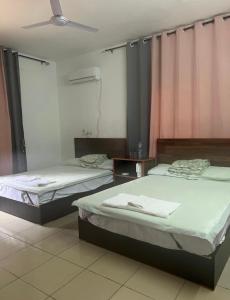 2 camas en una habitación con cortinas rosas en Hua Rui Hôtel 华睿之家 en Lomé
