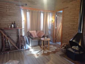 Chalés Corucacas في كامبارا: غرفة معيشة مع أريكة ومدفأة