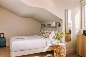 Un dormitorio con una gran cama blanca y una mesa en Yelo Mozart powered by Sonder en Niza