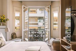 a bedroom with a bed and a balcony at Yelo Mozart powered by Sonder in Nice