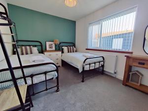 a bedroom with two bunk beds and a window at Coastal Bungalow in Prestatyn